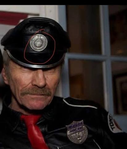 Durk Dehner wearing peaked leather cap with highlighted insignia